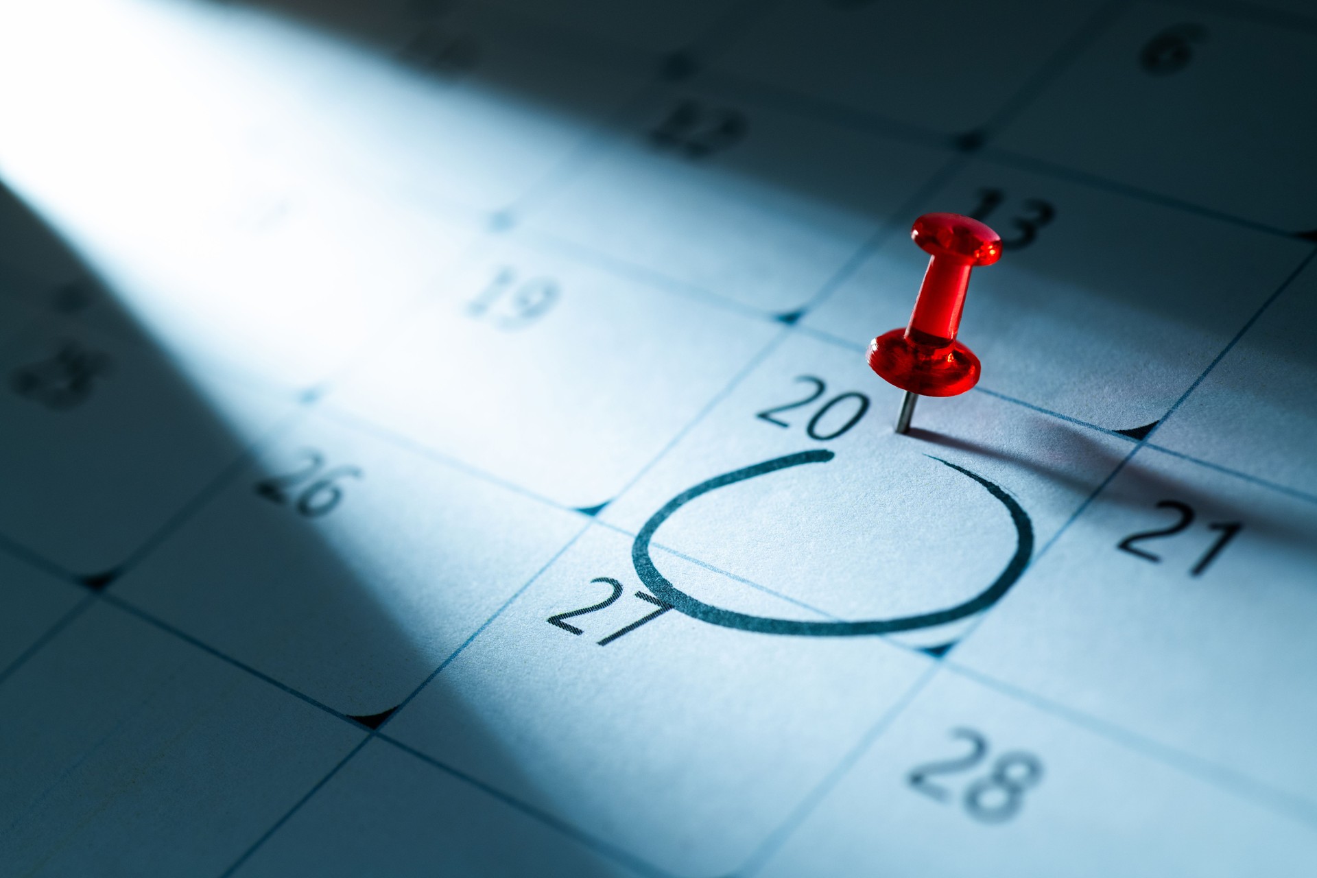 Red push pin on calendar with circle mark on 20