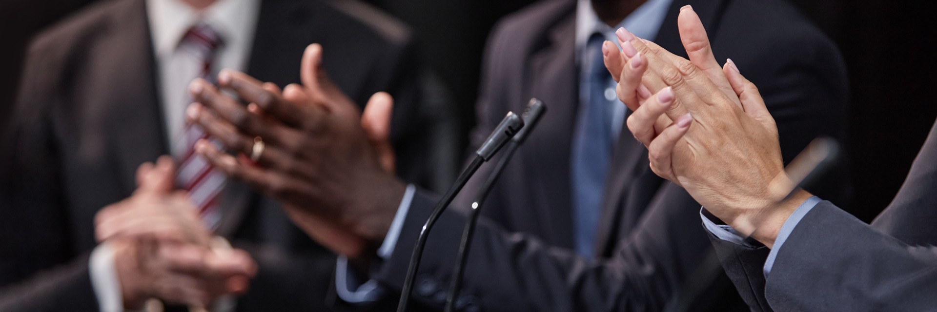 Header Image of Female Politician Clapping Hands Supporting Speaker Indoors